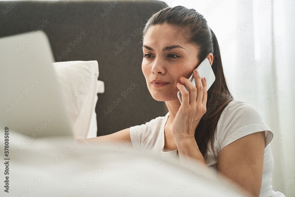 Attentive female telecommuter having a phone conversation Attentive female telecommuter having a phone conversation