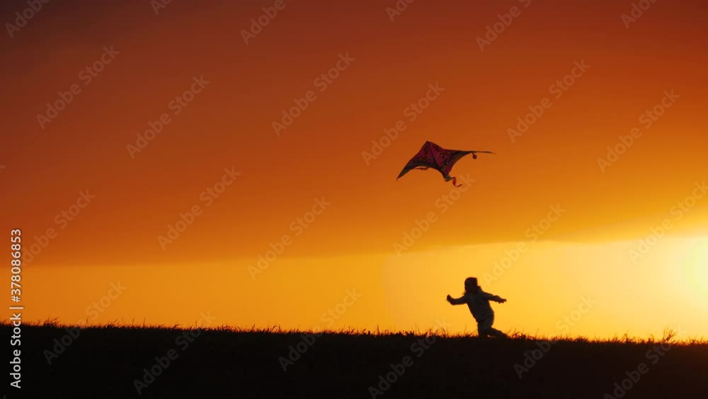 Silhouette of little girl launch kite, running across field at sunset Silhouette of little girl launch kite, running across field at sunset
