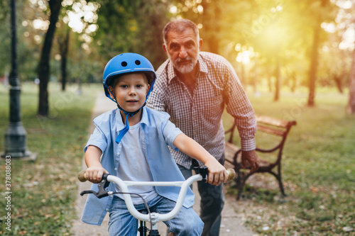 Wallpaper Mural boy riding bicycle with his grandfather at the city park Torontodigital.ca