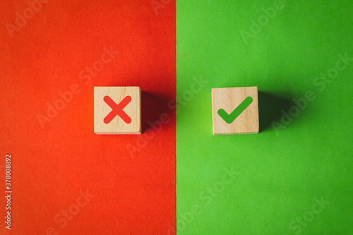 True and false symbols, Yes or No on wood cubes on red and green background. photo