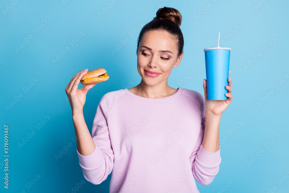 Photo of dreamy girl guess what eat hamburger or cold takeout cola glass with straw wear lilac violet sweater isolated over blue color background Photo of dreamy girl guess what eat hamburger or cold takeout cola glass with straw wear lilac violet sweater isolated over blue color background