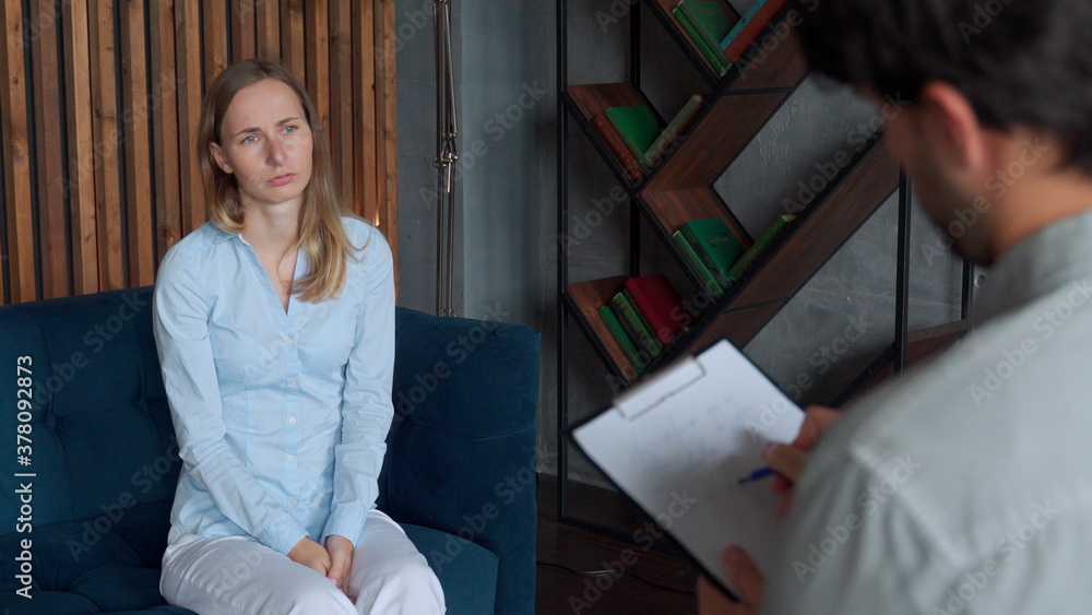 Obraz premium A mental health professional takes notes when a patient talks about problems while sitting on the couch