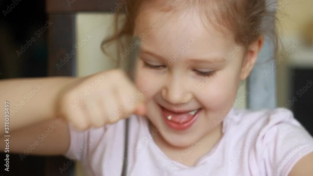 Funny child eats omelet in several pieces close up. Baby girl is hungry and has great appetite. Concept of home food and cooking Funny child eats omelet in several pieces close up. Baby girl is hungry and has great appetite. Concept of home food and cooking