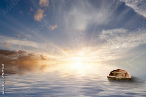 Old rowing boat adrift at sea