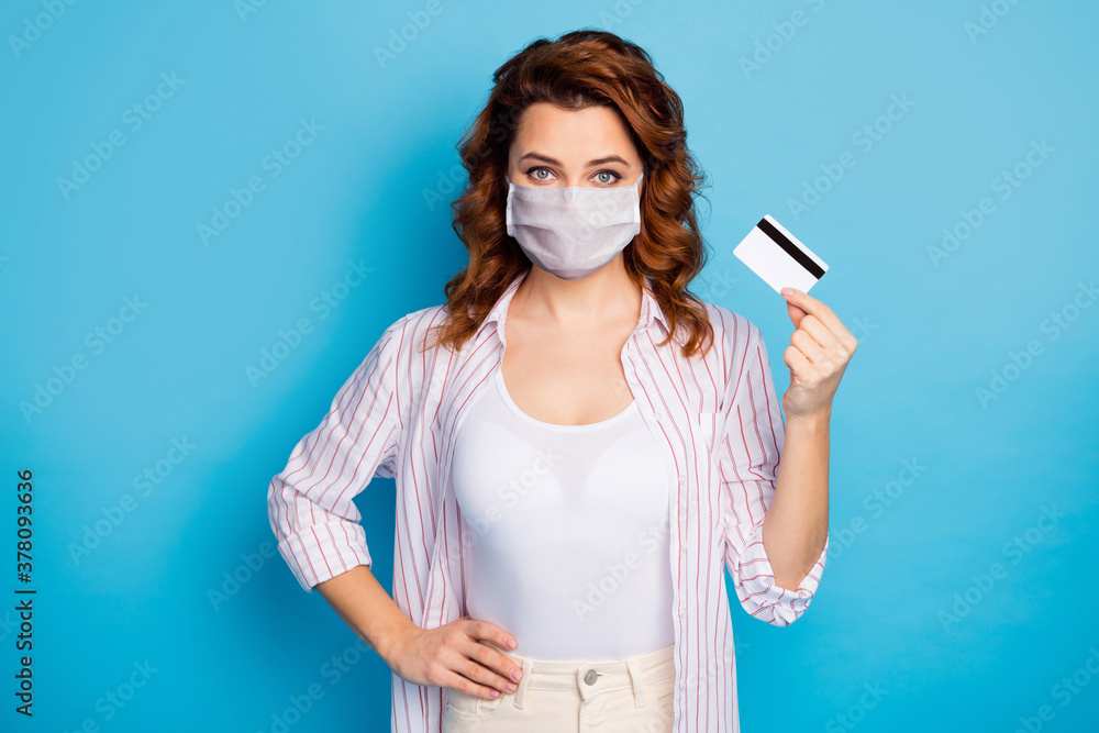 Portrait of her she nice attractive confident wavy-haired girl holding in hand plastic card banking service covid quarantine wear medical mask isolated on bright blue color background Portrait of her she nice attractive confident wavy-haired girl holding in hand plastic card banking service covid quarantine wear medical mask isolated on bright blue color background