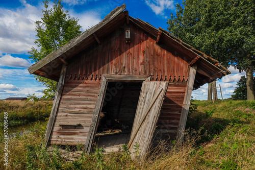 Saby, Sweden  An abandoned and dilapidated red cabin in a field photo