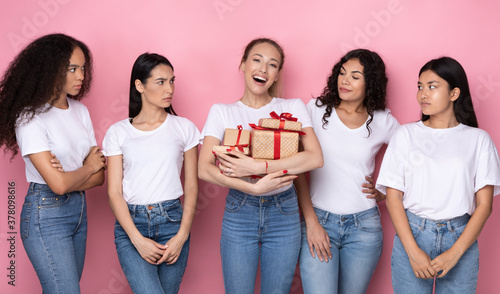 Fotografie Envious Women Looking At Friend With Many Gifts, Pink Background