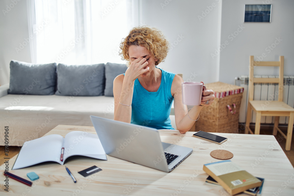 Woman working from home and being depressed, tired with headache. Modern concept and problems with freelancers. Woman working from home and being depressed, tired with headache. Modern concept and problems with freelancers.