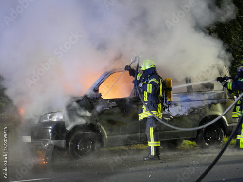 Feuerwehr im Einsatz und löscht brennendes Fahrzeug
