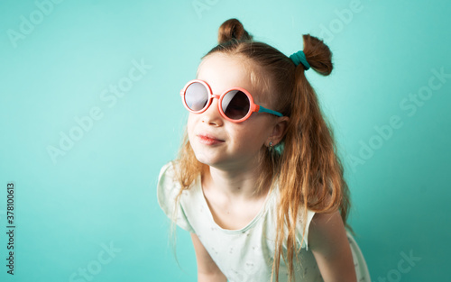 Bright colors: a girl in sunglasses on a green background.