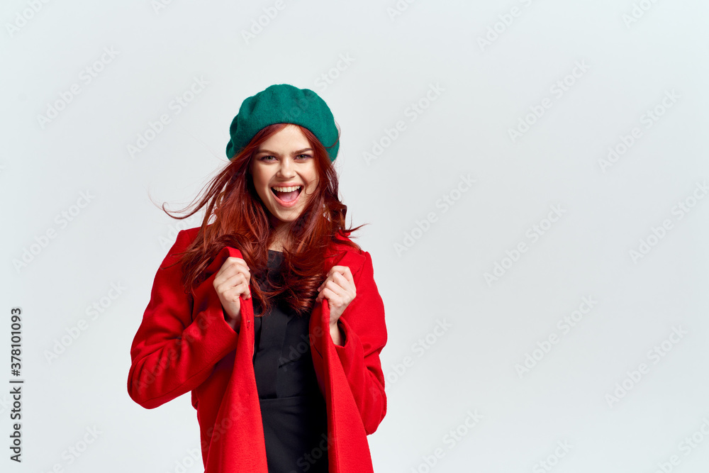 Portrait of a woman in a red coat and in a green hat dark clothes light background model cropped view Portrait of a woman in a red coat and in a green hat dark clothes light background model cropped view