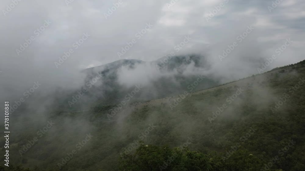 Forested mountain in low lying cloud with trees in mist in a scenic landscape view Forested mountain in low lying cloud with trees in mist in a scenic landscape view