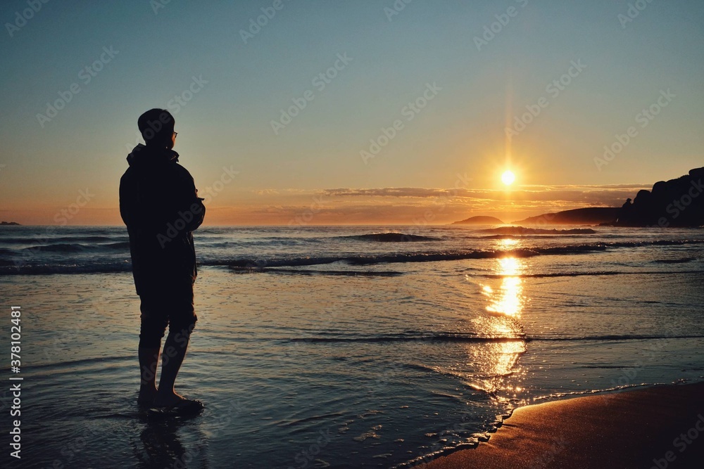 silhouette of a person on the beach at sunset silhouette of a person on the beach at sunset