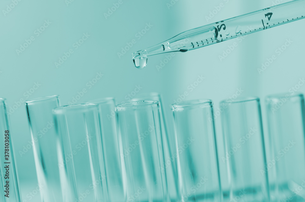 Pipette dropping a sample into a test tube and science experiments