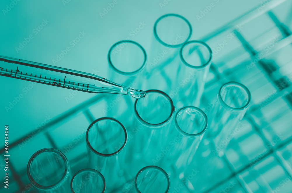 Pipette dropping a sample into a test tube and science experiments