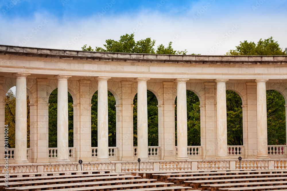 Fototapeta premium Column, benches and scene The Arlington Memorial Amphitheater at National Cemetery, Virginia with dark gloomy sky