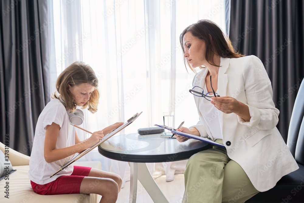Obraz premium Child psychologist talking to girl kid in office