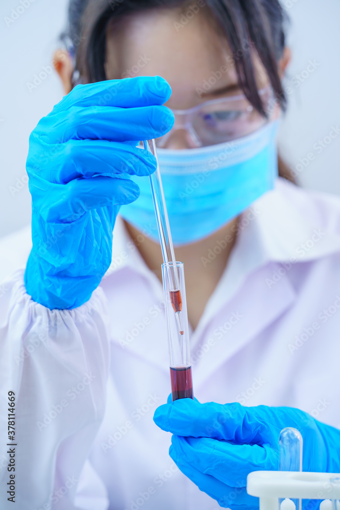 Scientist analyzing a blood sample in test tube Scientist analyzing a blood sample in test tube