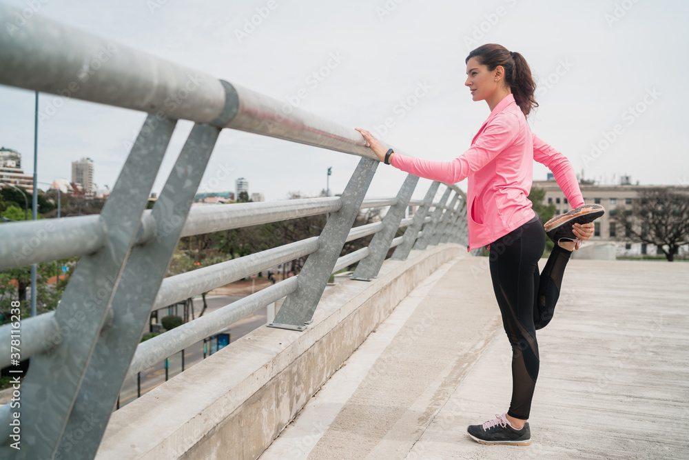 Fototapeta premium Athletic woman stretching legs before exercise.