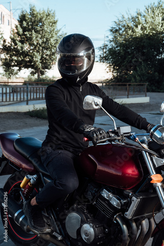 Man seat on the motorcycle.Motorcyclist in black helmet on a red bike © bo.kvk