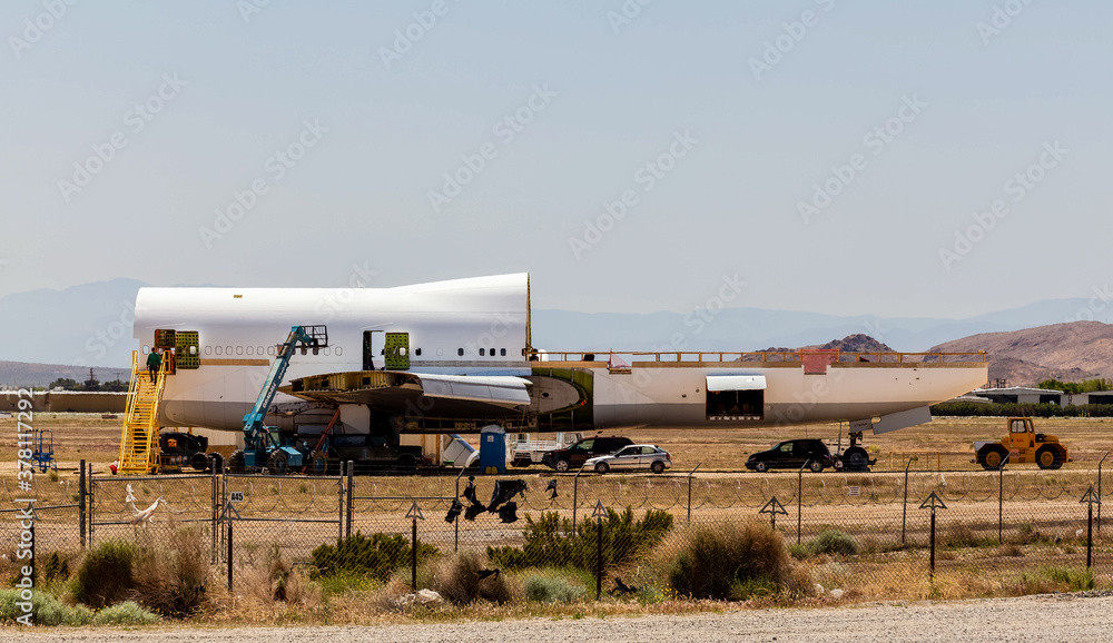 Fototapeta premium An aircraft bone yard disassembles a jumbo jet piece by piece to be reused or recycled.
