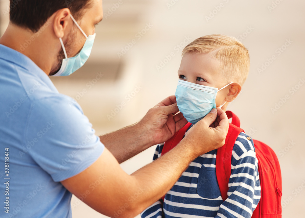 Man putting medical mask on son before going to school Man putting medical mask on son before going to school