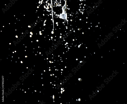 Splashes of white milk isolated on a black background.