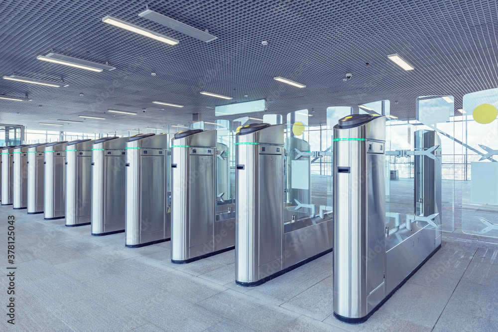 Naklejka premium Turnstiles with electronic card readers on the station platform.