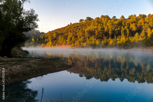 Reflection of the hill illuminated by the morning sun in the waters of Lake Bimont, commune of Saint-Marc-Jaumegarde, region of Provence-Alpes-Côte d'Azur, department of Bouches-du-Rhône, France