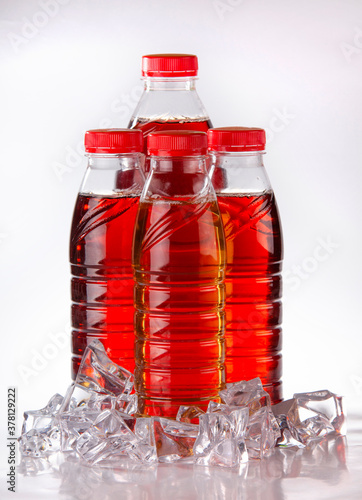 Three bottles with ice tea, decorated with ice cubes and tea leaves