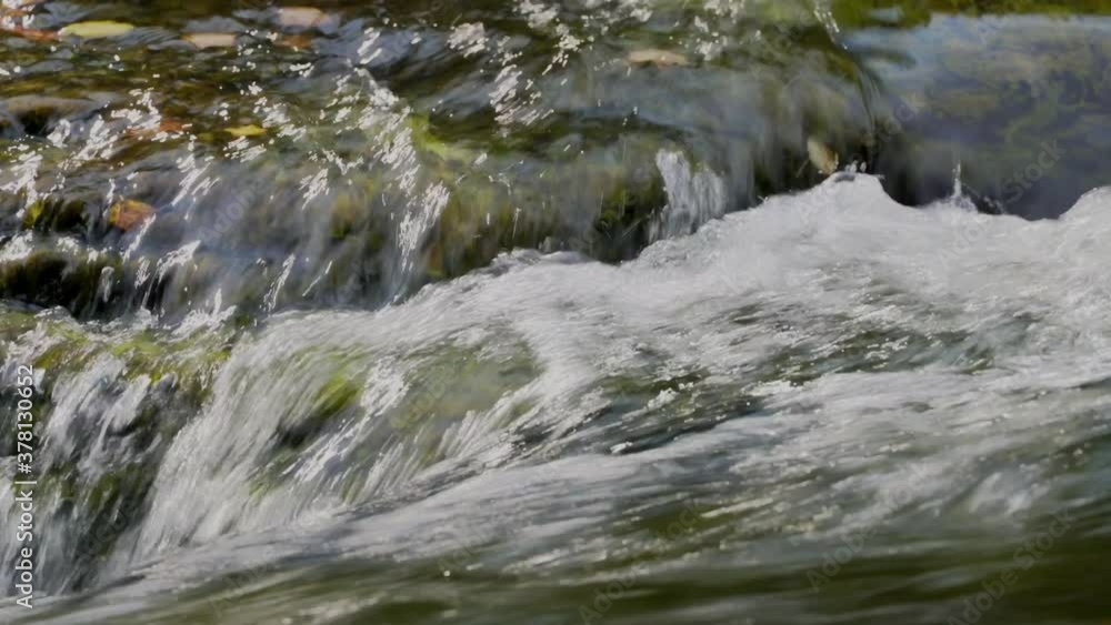 Close up of clean clear water rushing over rocks in a river stream. Close up of clean clear water rushing over rocks in a river stream.