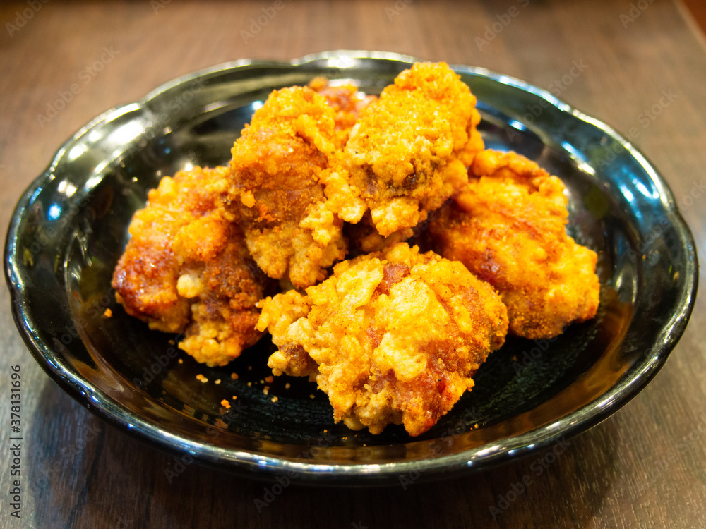 Fried chicken in Japanese style (karaage) in black plate background Fried chicken in Japanese style (karaage) in black plate background