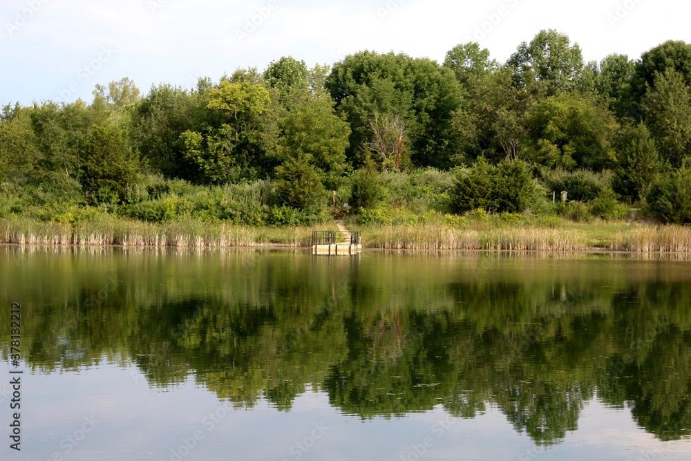 The peaceful lake and the reflections of the trees in water.