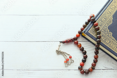 Holy book Quran and muslim rosary on table with copy space  photo