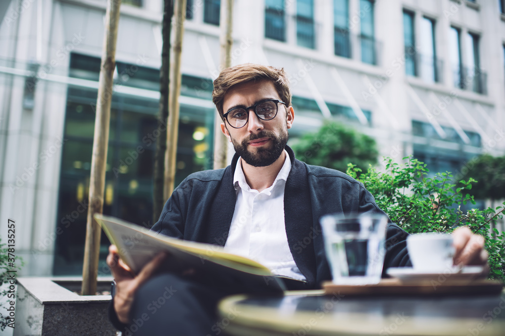 Relaxed businessman with newspaper in sidewalk cafe Relaxed businessman with newspaper in sidewalk cafe