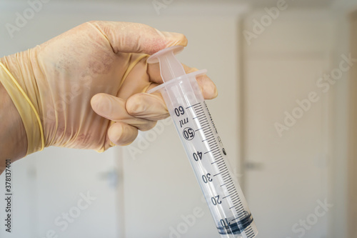  clinical syringe being used to administer a vaccine like coronavirus pandemic covid -19  via an injection by a physician or medical nurse