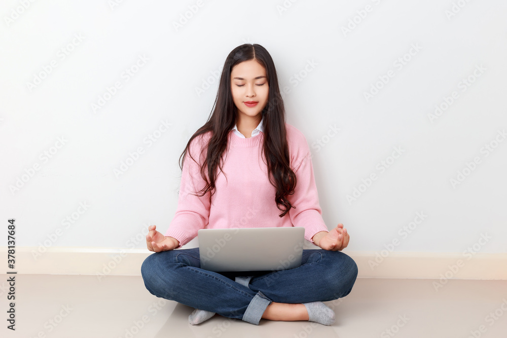 Portrait of young attractive Asian woman as a student sitting with laptop, smart phone, Doing meditation during the break, Asian woman with pink long sleeve shirt study online from home. Portrait of young attractive Asian woman as a student sitting with laptop, smart phone, Doing meditation during the break, Asian woman with pink long sleeve shirt study online from home.