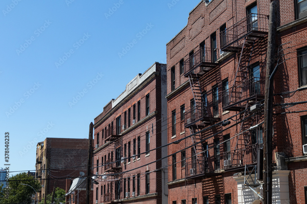 Row of Old Brick Apartment Buildings with Fire Escapes in Astoria Queens New York