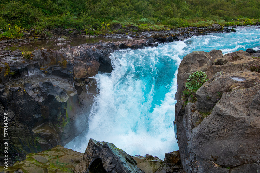 Hier sieht man den wilden Midfoss Waterfall in seinem wunderschönen Blauton