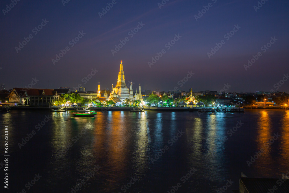 The illuminated temple of Wat Arun on the Chao Phraya river at sunset/night in Bangkok, Thailand