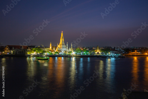 The illuminated temple of Wat Arun on the Chao Phraya river at sunset/night in Bangkok, Thailand