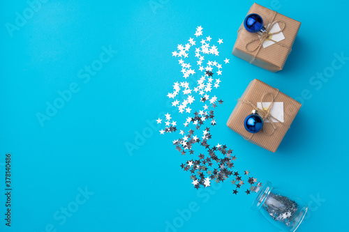 Wrapped Christmas gifts with confetti on blue background