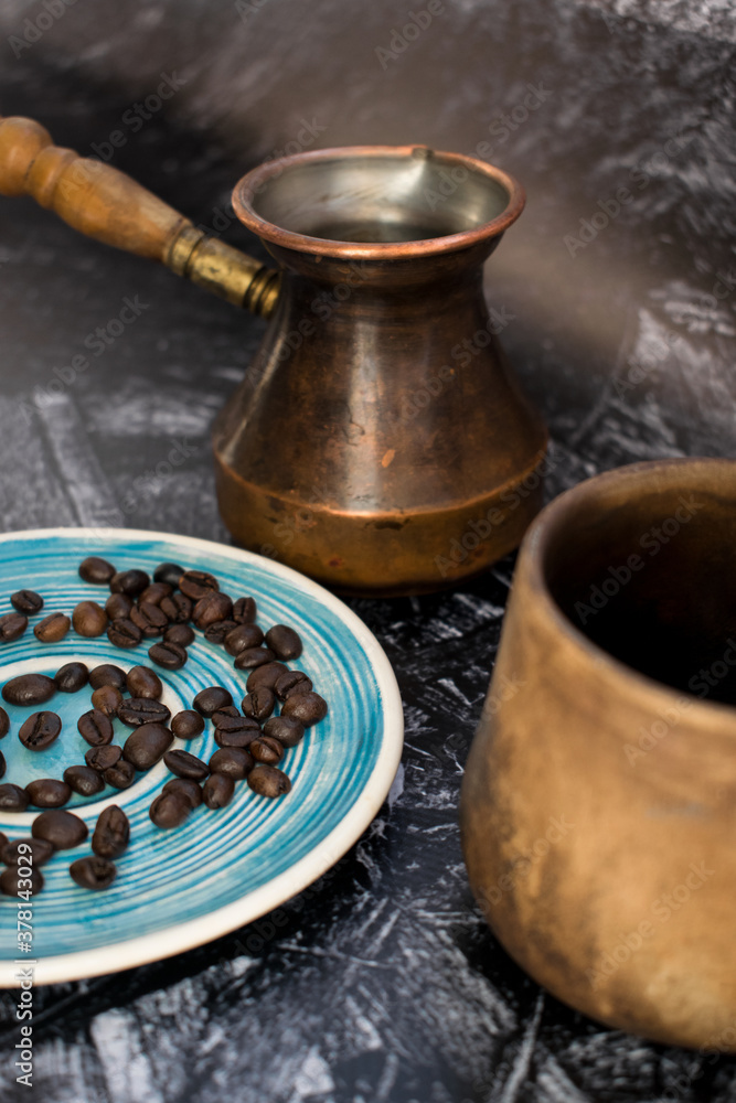 Cezve and roasted coffee beans on black marble background. Vertical photo Cezve and roasted coffee beans on black marble background. Vertical photo