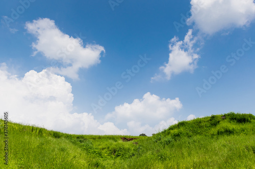 View of lush green hill landscape with clouds as background in rural Maharashtra