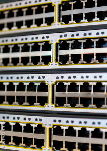 A stack of network switches with empty ports exposed just removed from a server cabinet in an office.