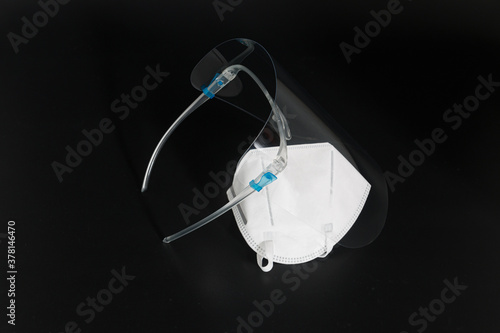 White mask with Face shield on a black background.Concept protection against for health and Spread of COVID 19 photo