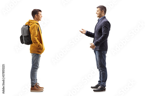 Full length profile shot of a father talking to his teenage student son