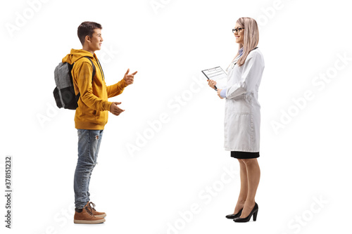 Full length profile shot of a teenager boy talking to a young female doctor