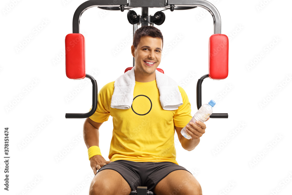 Naklejka premium Portrait of a smiling man on a fitness machine holding a bottle of water