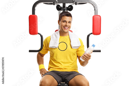 Portrait of a smiling man on a fitness machine holding a bottle of water